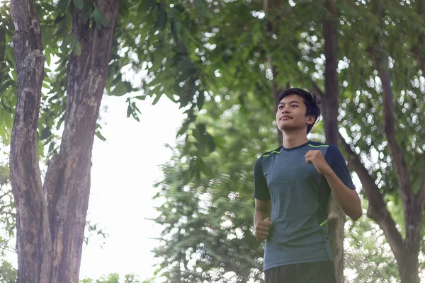 asian young fitness man runner running at the park
