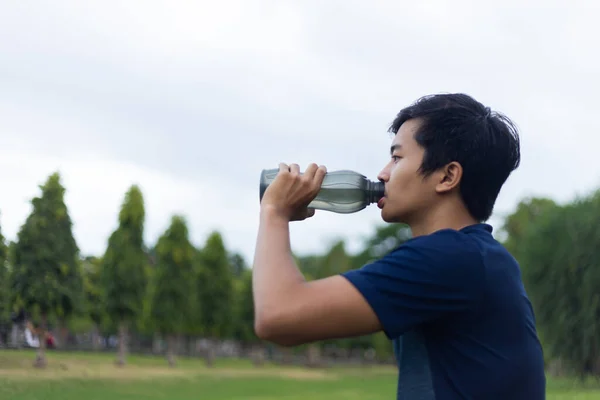 Genç fitness adamı su içiyor.