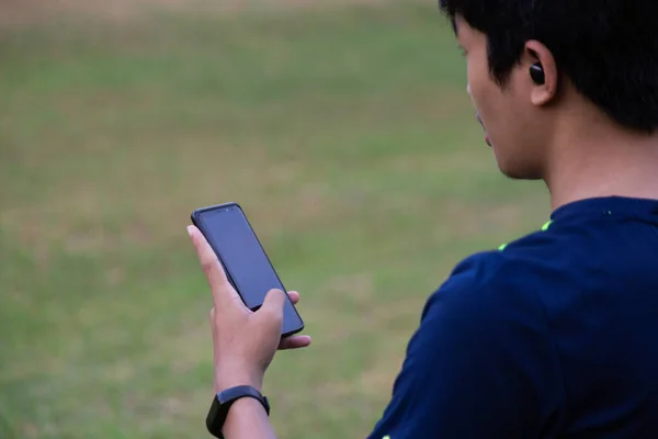 Fitness elemanı kablosuz kulaklıklı akıllı telefon kullanıyor.