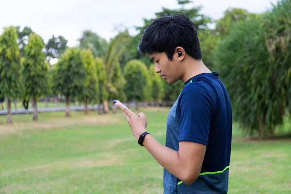 Młody Fitness Parku Słuchawkach Bezprzewodowych Smartwatch Sprawdzanie Telefonu Komórkowego — Zdjęcie stockowe