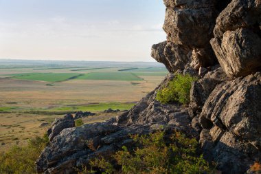 Altın saatinde yeşil tarlaların üzerindeki kayaları kapatın..