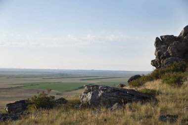 Yeşil tarlaların üzerindeki kayalıkların güzel manzarası.