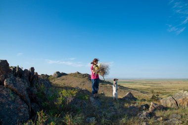 Dağda köpeği olan kız aşağıdaki tarlaların manzarasına bak..