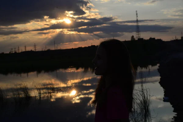 Silhouette Eines Lächelnden Mädchens Vor Dem Hintergrund Des Sonnenuntergangs Der — Stockfoto