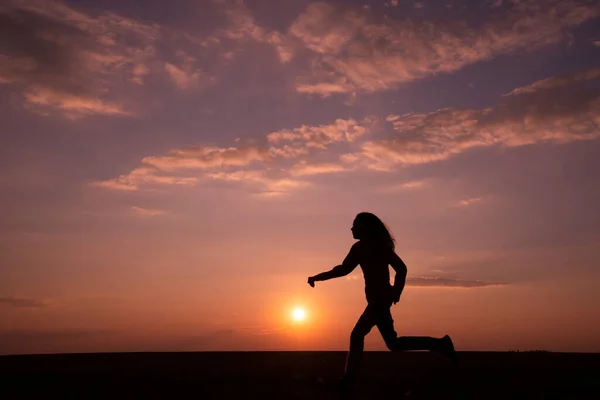 Dunkle Silhouette Eines Mädchens Mit Langen Haaren Das Bei Sonnenuntergang — Stockfoto