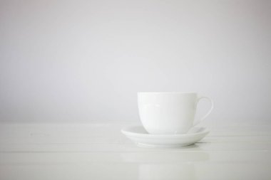 Beyaz arka planda fincan tabağı ile beyaz seramik fincan 