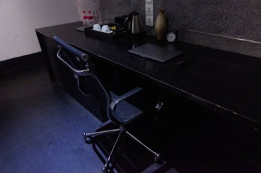 Dizüstü bilgisayarı, saati ve çay yapma seti olan ofis alanı