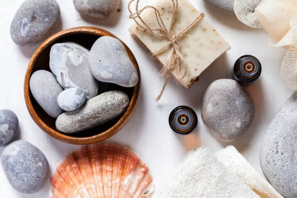 Spa composition with essence oil, stones, handmade natural soap, soft towel, shell. Flat lay top view, close up, macro
