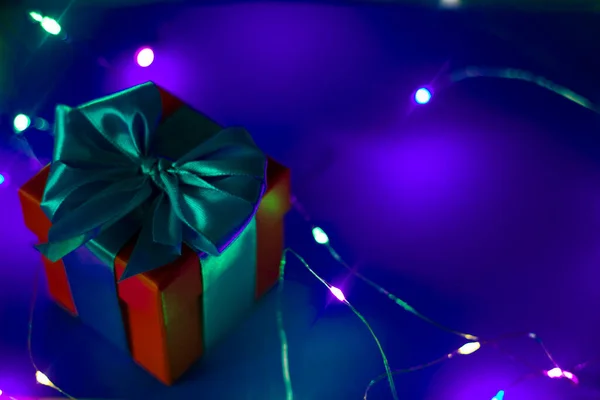 Rote Geschenkschachtel mit blauem Band auf blauem Hintergrund — Stockfoto