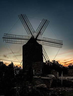Gün batımında eski değirmen. Uzun pozlama. Mavi gün batımı.