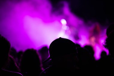 Konserde arka planı aydınlanmış insanlar. Seçici odaklanma. Boşluğu kopyala.