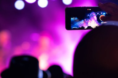 Cep telefonuyla konser kaydeden biri. Seçici odaklanma. Boşluğu kopyala.