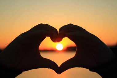 Güneşin karşı şeklinde el kalp