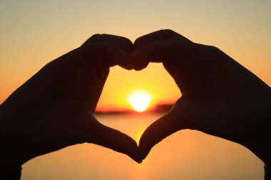 Güneşin karşı şeklinde el kalp