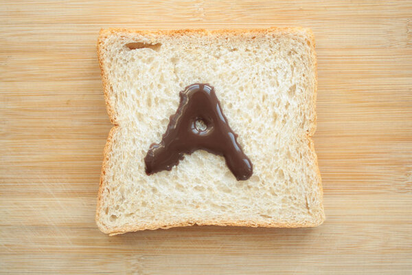 Алфавит, нарисованный на куске хлеба
