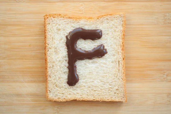 Алфавит Нарисованный Куске Хлеба — стоковое фото