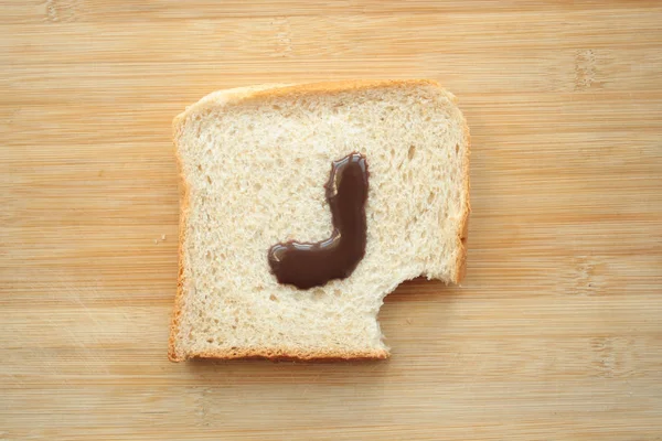 Алфавит Нарисованный Куске Хлеба — стоковое фото