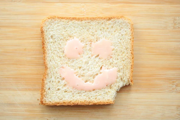 Счастливое Лицо Нарисованное Куске Хлеба — стоковое фото