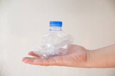 Plastik bir şişeyi elle ez.