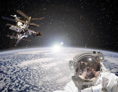 Astronot, uzay istasyonu ve arka planda gün doğumu. Elemen