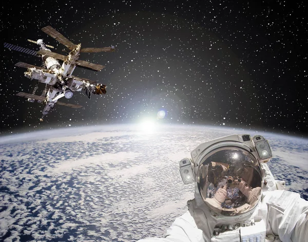 Astronaut, rymdstation och soluppgång i bakgrunden. Den eleme — Stockfoto