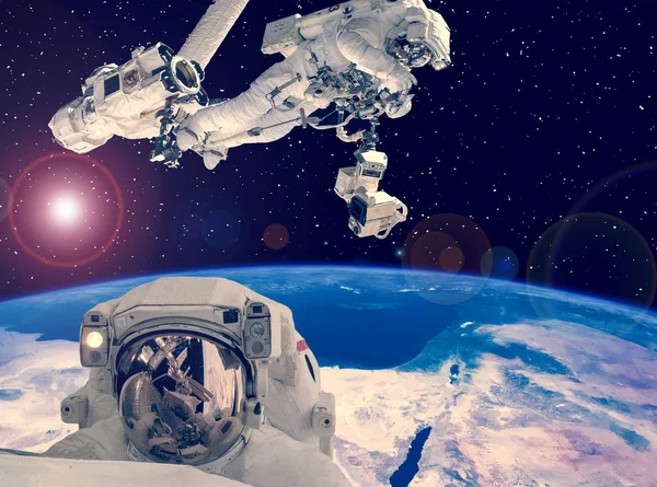 Astronot uzay yürüyüşü. Arka planda diğer astronotlar. Uzay scen