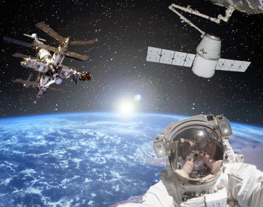 Astronot, uzay gemileri ve arka planda gün doğumu. Elementler 