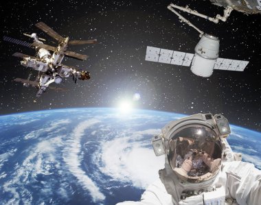 Astronot, uzay gemileri ve arka planda gün doğumu. Elementler 