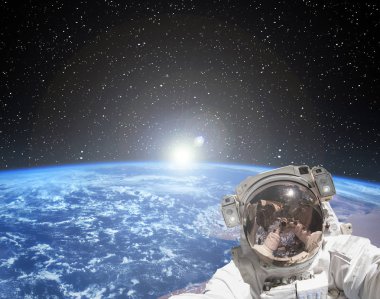 Astronot gün doğumuna karşı selfie çekiyor. Bu imanın unsurları
