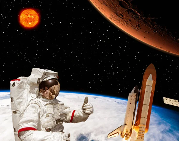 Raket flyger från jorden till mars. Astronauten visar tummen upp. — Stockfoto