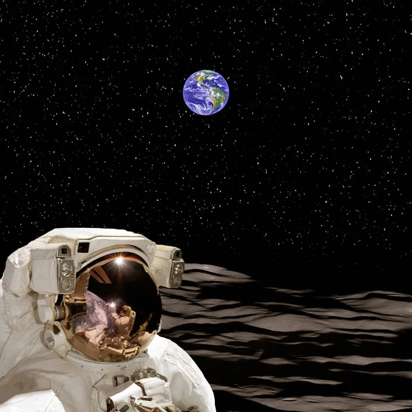 Astronauta na lua e no planeta Terra em segundo plano. O el — Fotografia de Stock
