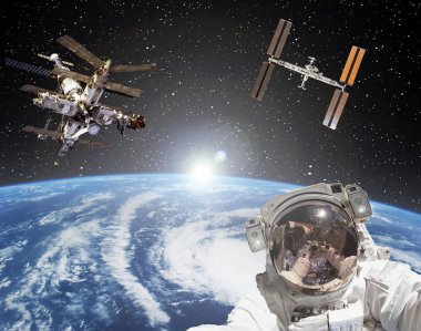 Astronot, uzay istasyonları ve arka planda gün doğumu. Eleme