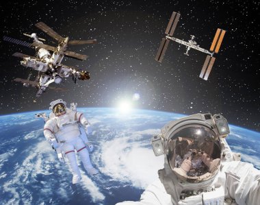 Astronot, uzay istasyonları ve arka planda gün doğumu. Eleme