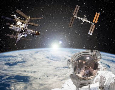 Astronot, uzay istasyonları ve arka planda gün doğumu. Eleme