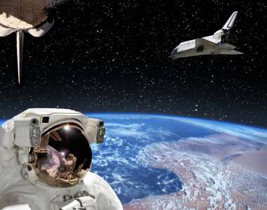 Astronot uzayda uçan mekiğe bakıyor. Diğer spaceshi