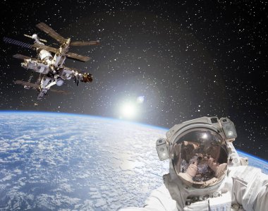 Astronot, uzay istasyonu ve arka planda gün doğumu. Elemen
