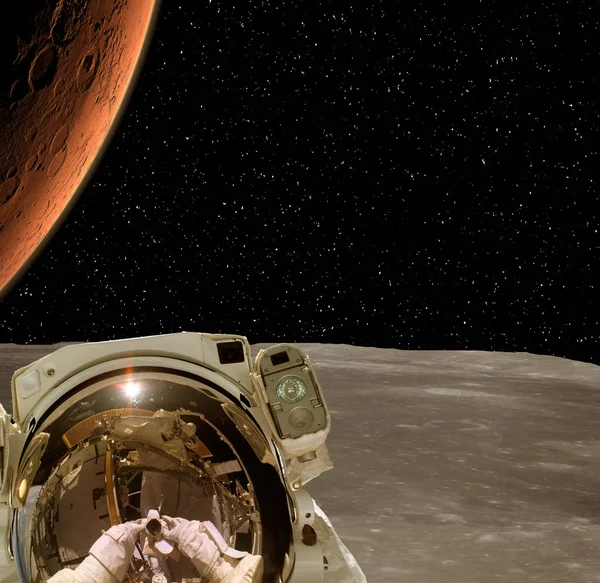 Astronauta posando em planeta extrassolar. Terra em segundo plano . — Fotografia de Stock