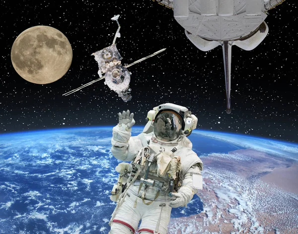 Astronaut in outer space, moon and spaceships on the backdrop. T