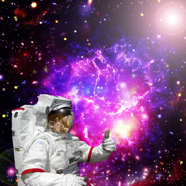 Astronauta da pulgares hacia arriba contra el espacio exterior, galaxias y estrellas — Foto de Stock