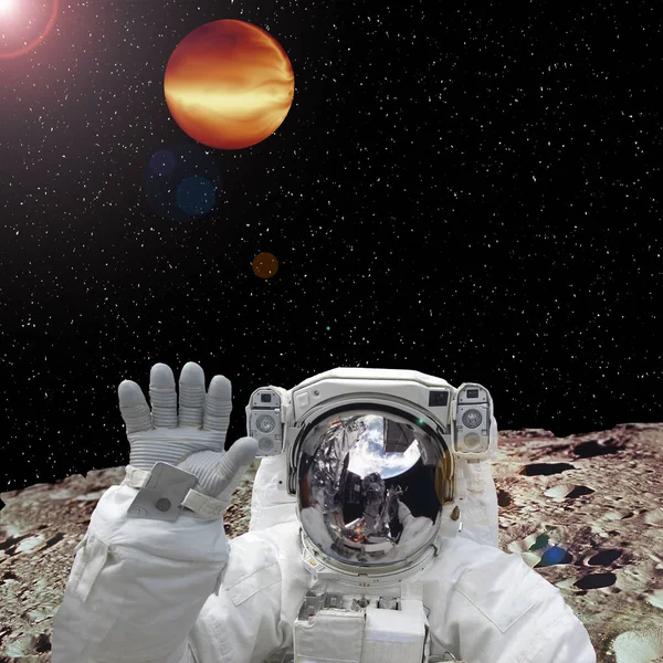 Astronautti ekstrasolaarisella planeetalla. Toinen planeetta taustalla — kuvapankkivalokuva