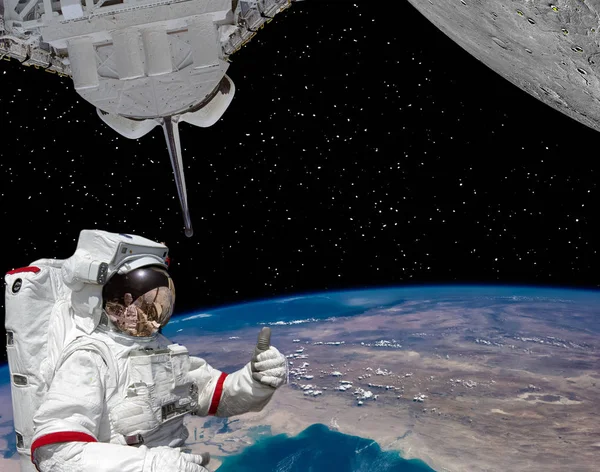 Astronauta daje kciuki, ziemię i planetę z kraterów jak mo — Zdjęcie stockowe