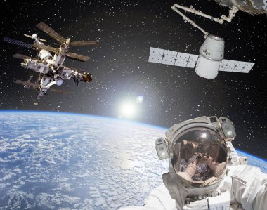 Astronot, uzay gemileri ve arka planda gün doğumu. Elementler 