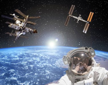 Astronot, uzay istasyonları ve arka planda gün doğumu. Eleme