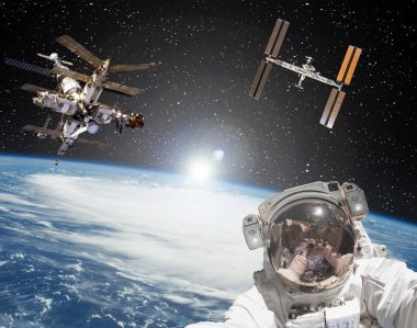 Astronot, uzay istasyonları ve arka planda gün doğumu. Eleme