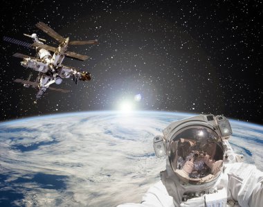 Astronot, uzay istasyonu ve arka planda gün doğumu. Elemen