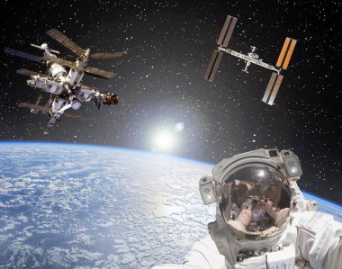 Astronot, uzay istasyonları ve arka planda gün doğumu. Eleme