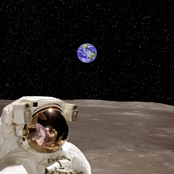 Astronauta na lua e no planeta Terra em segundo plano. O el — Fotografia de Stock