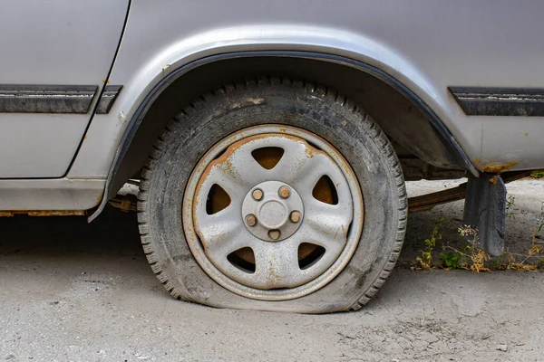 Stary Szary Samochód Przebitym Kołem Zewnątrz Uszkodzona Guma Samochodzie Opuszczony — Zdjęcie stockowe