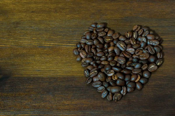 Kahverengi Ahşap Arka Planda Kalp Şeklinde Kahve Çekirdekleri Tahta Yüzeyde — Stok fotoğraf