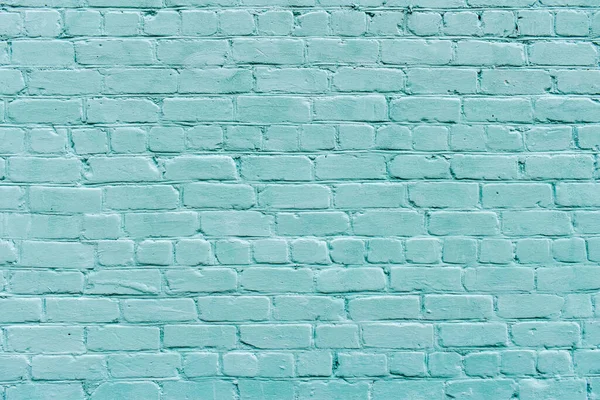 Large texture of light blue brick wall, textured surface. Brick background. Pastel blue brick wall. Turquoise painted old wide angle brickwork backdrop. Grainy texture